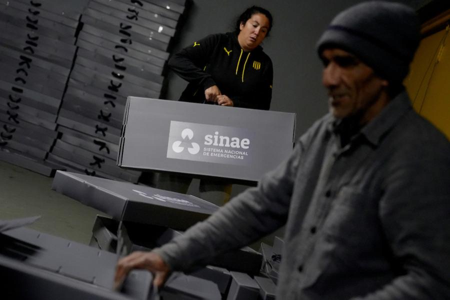 Voluntarios durante la preparación de las camas para el refugio en el Palacio Peñarol en Montevideo. Foto: Javier Calvelo / adhocFOTOS