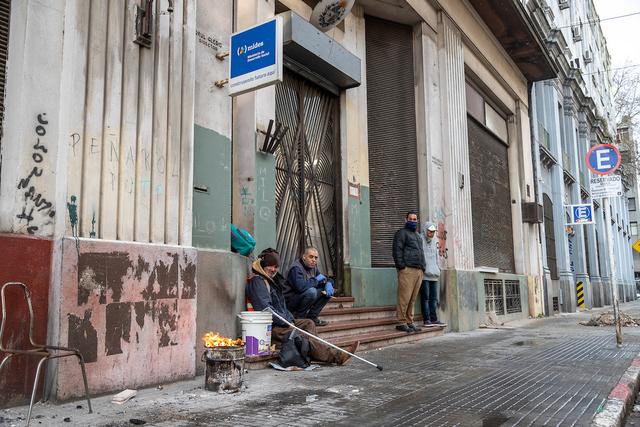 Personas en situacion de calle esperan para ingresar en el refugio nocturno de Paysandu y Rio Branco en el centro de Montevideo Foto: Mauricio Zina/ adhocFOTOS